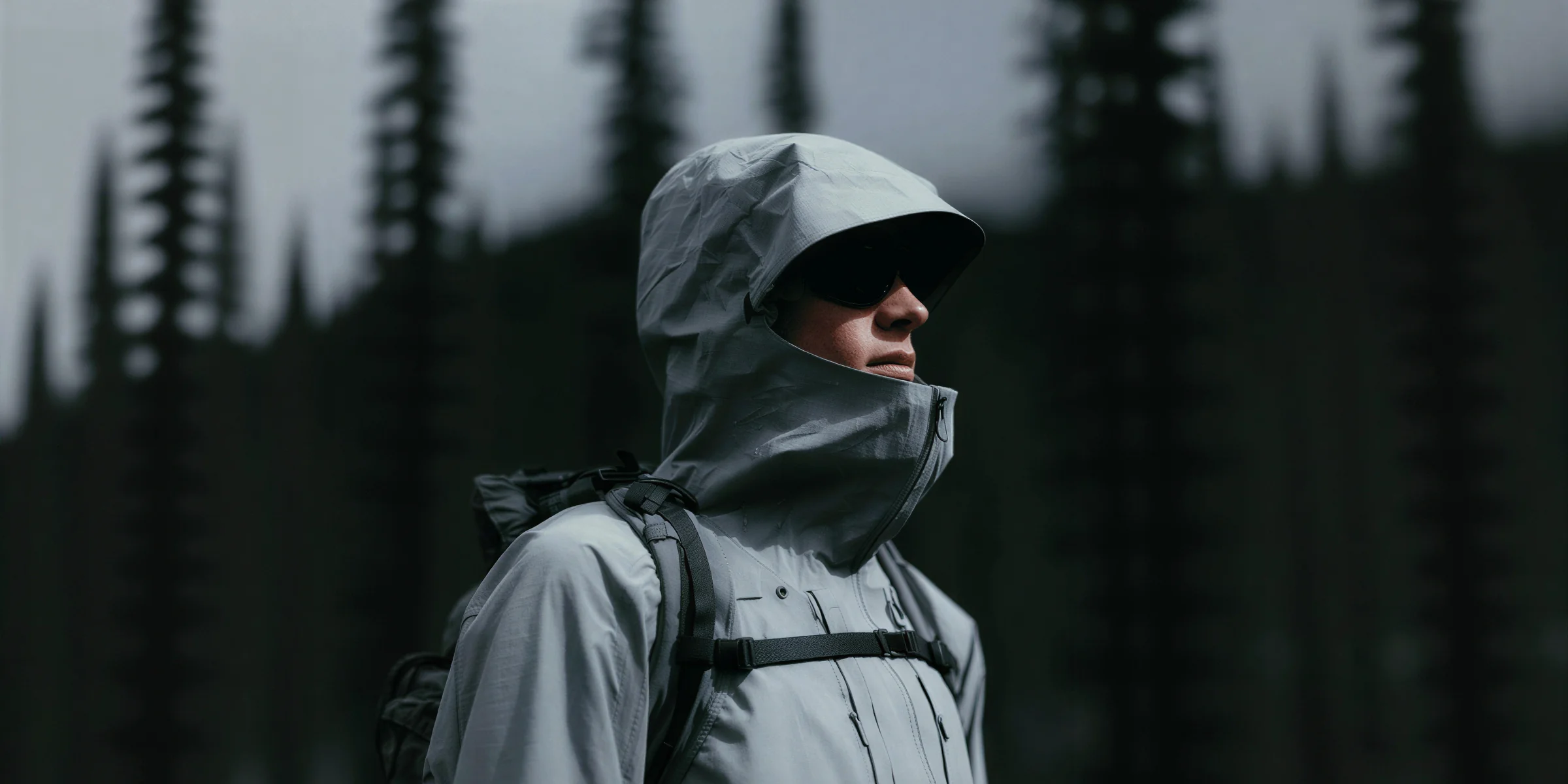Person in technical outerwear standing in a forest
